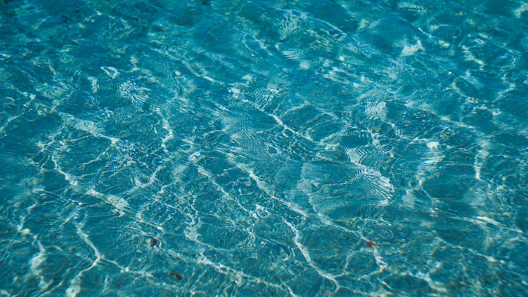 Abstract photo of clear blue water with delicate ripples creating a textured surface.