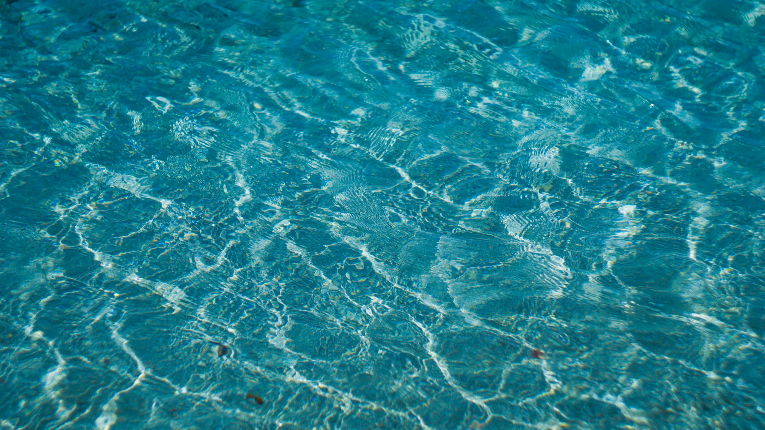 Abstract photo of clear blue water with delicate ripples creating a textured surface.